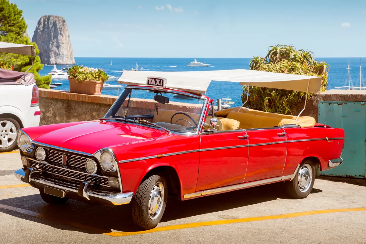 Un taxi décapotable rouge vintage garé près de la côte